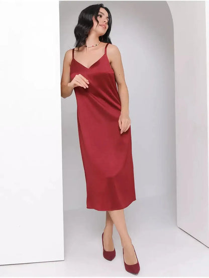 Model showcasing the Satin Charm Midi Dress in burgundy, featuring adjustable straps and a fluid silhouette.