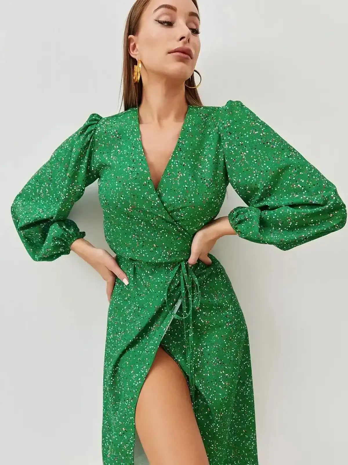 Elegant green midi dress with wrap design and speckled dot print, perfect for wedding guest or party attire.