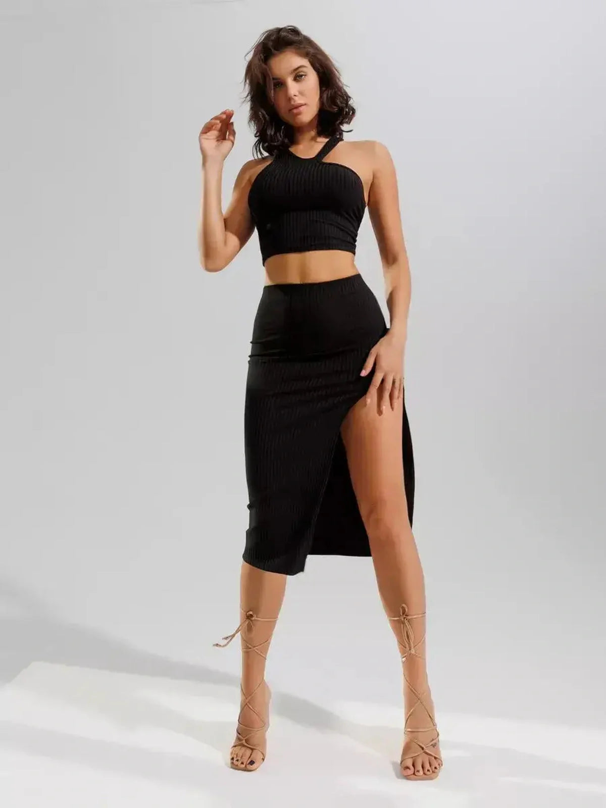 Sculpted Edge Set: Black ribbed knit two-piece featuring a one-shoulder crop top and high-waisted midi skirt with side slit.