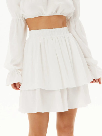 White ruffle mini skirt featuring a tiered design, perfect for summer occasions and stylish outfit pairings.