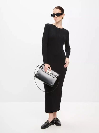 Chic model showcasing a Sculpted Rib Maxi Dress in black, accessorized with sunglasses and a stylish handbag.
