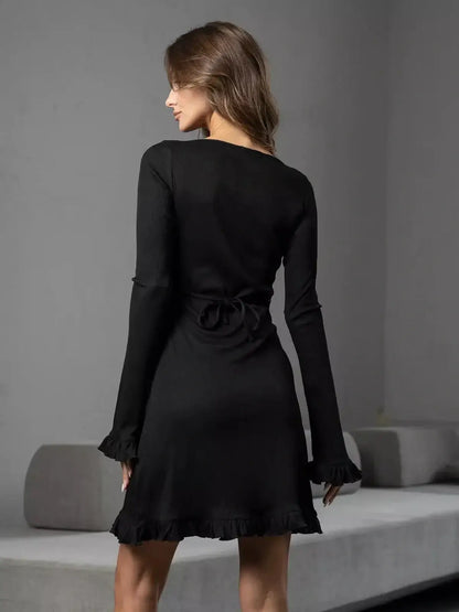 Back view of the Noir Flare dress showcasing its ruffled trim and lace-up detail for a chic silhouette.