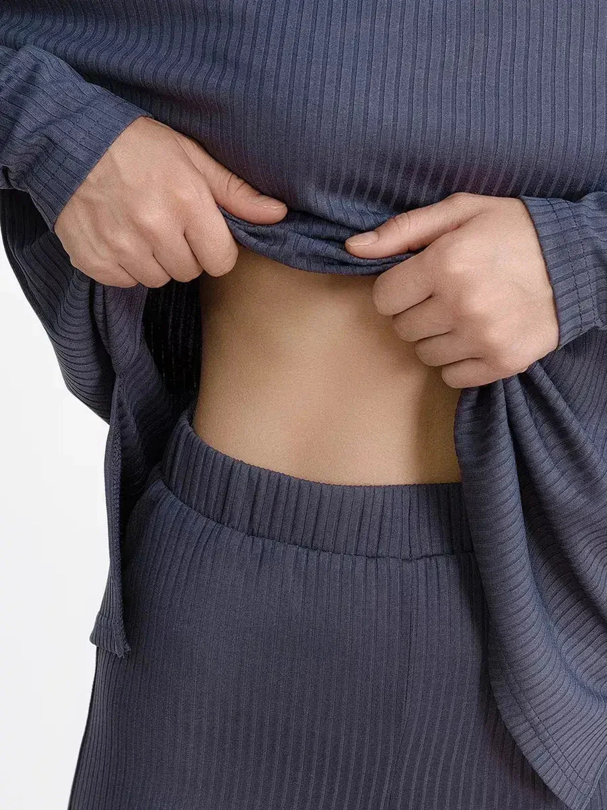 Close-up of a woman adjusting her top from the Slate Lounge Set, showcasing its soft ribbed knit design.
