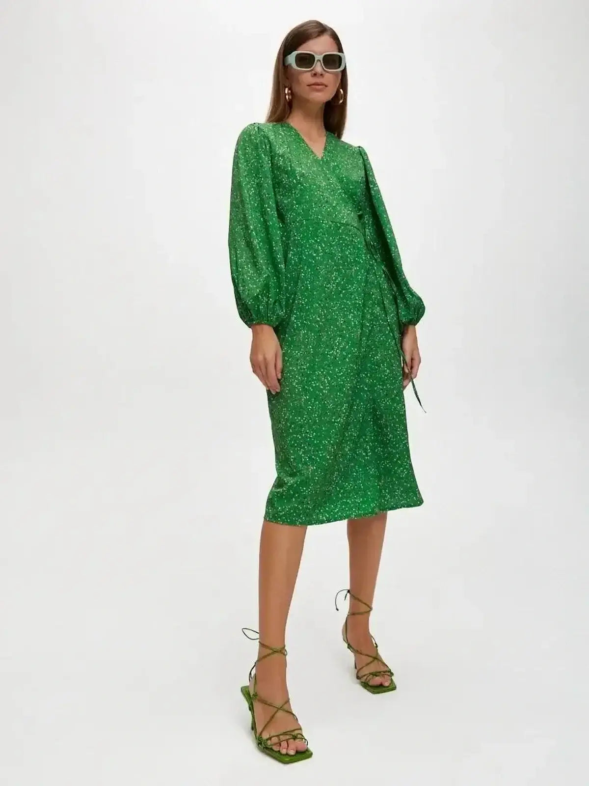 Elegant green midi dress with speckled dot print, perfect for summer events like weddings or parties.