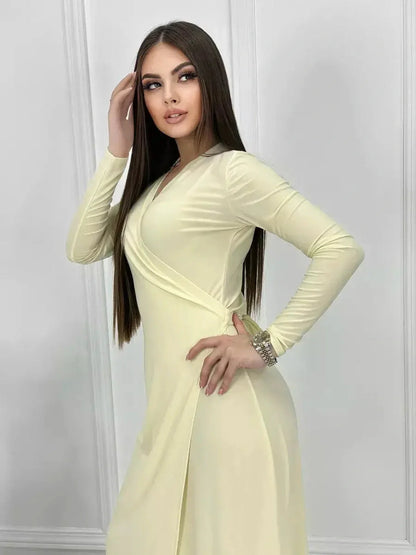 Model showcasing the Celeste Wrap Maxi Dress in buttercream, featuring a sleek silhouette and graceful draping.