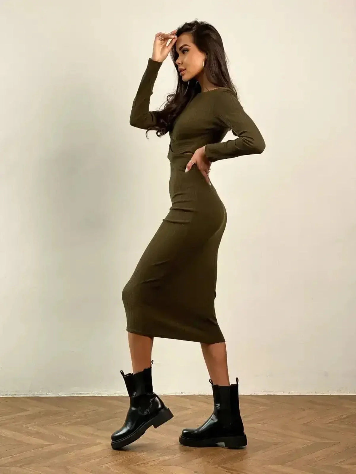 Woman in olive green Verona Midi Dress showcasing a sleek silhouette, paired with stylish black ankle boots for a modern look.