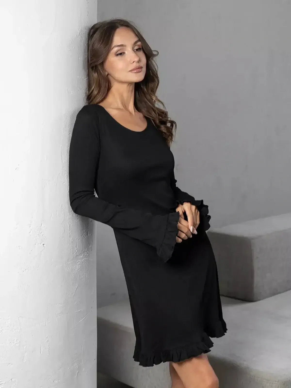 Woman in a black mini dress with ruffled sleeves, ideal for weddings, proms, or casual summer outings.