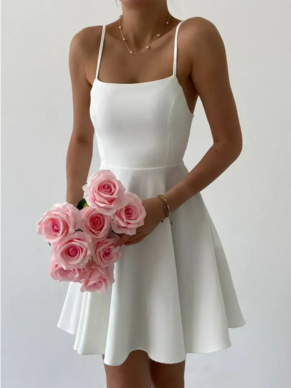 Model wearing a white Laceback Muse A-line dress, holding pink roses, perfect for summer weddings and graduation celebrations.
