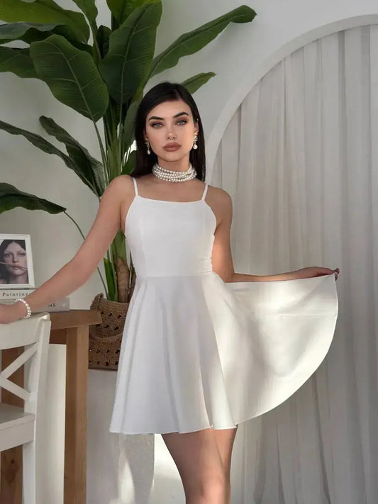 Model wearing a chic white dress with a flared skirt, perfect for summer occasions and elegant events.