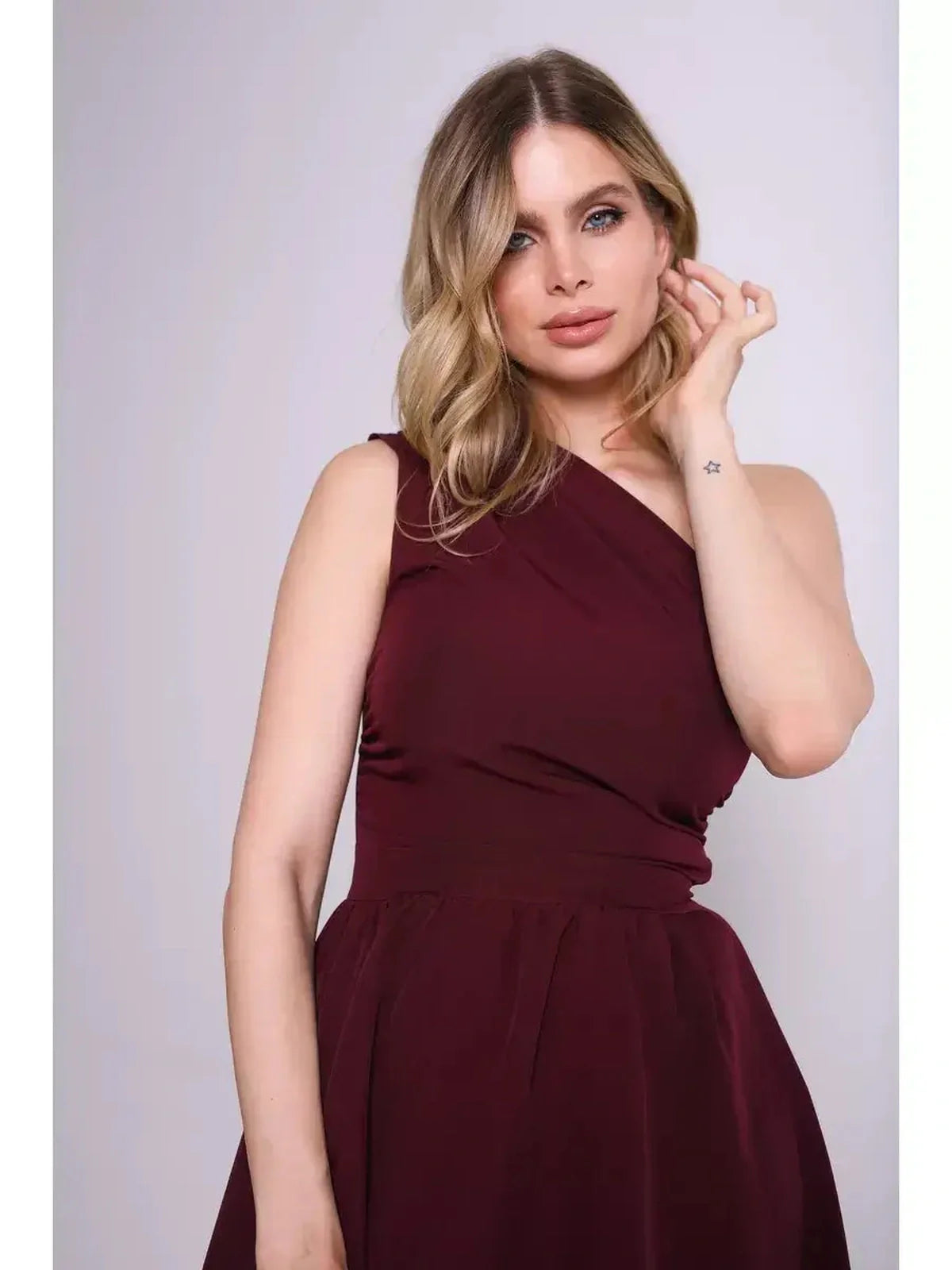 Model showcasing the Opéra Midi Dress in a rich wine hue, featuring an elegant one-shoulder design perfect for formal occasions.