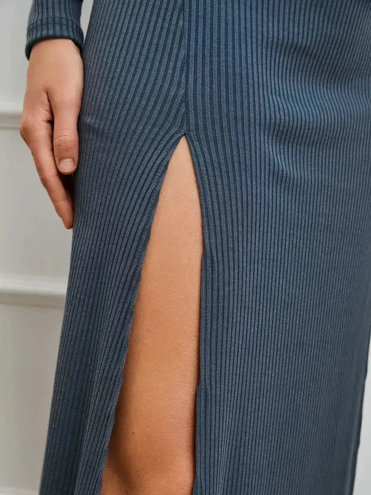 Detail of the Midnight Slit Midi Dress showcasing bold side slit and ribbed knit texture for elegant fashion.