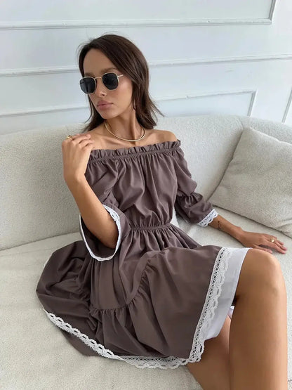 Model wearing the Mocha Muse off-shoulder mini dress in brown with white lace trim, perfect for summer occasions.