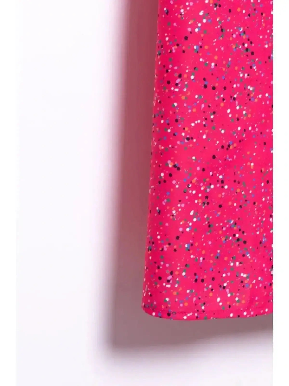 Close-up of the vibrant pink fabric of the Confetti Bloom Midi Dress featuring a playful speckled pattern.