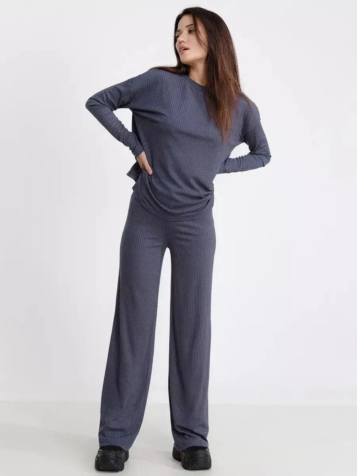 Stylish woman in a relaxed-fit slate lounge set featuring long sleeves and wide-leg pants, perfect for casual outings.