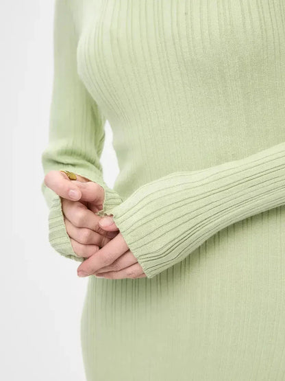 Close-up of the Celery Luxe Maxi Dress in light green ribbed fabric, highlighting long sleeves and elegant fit.