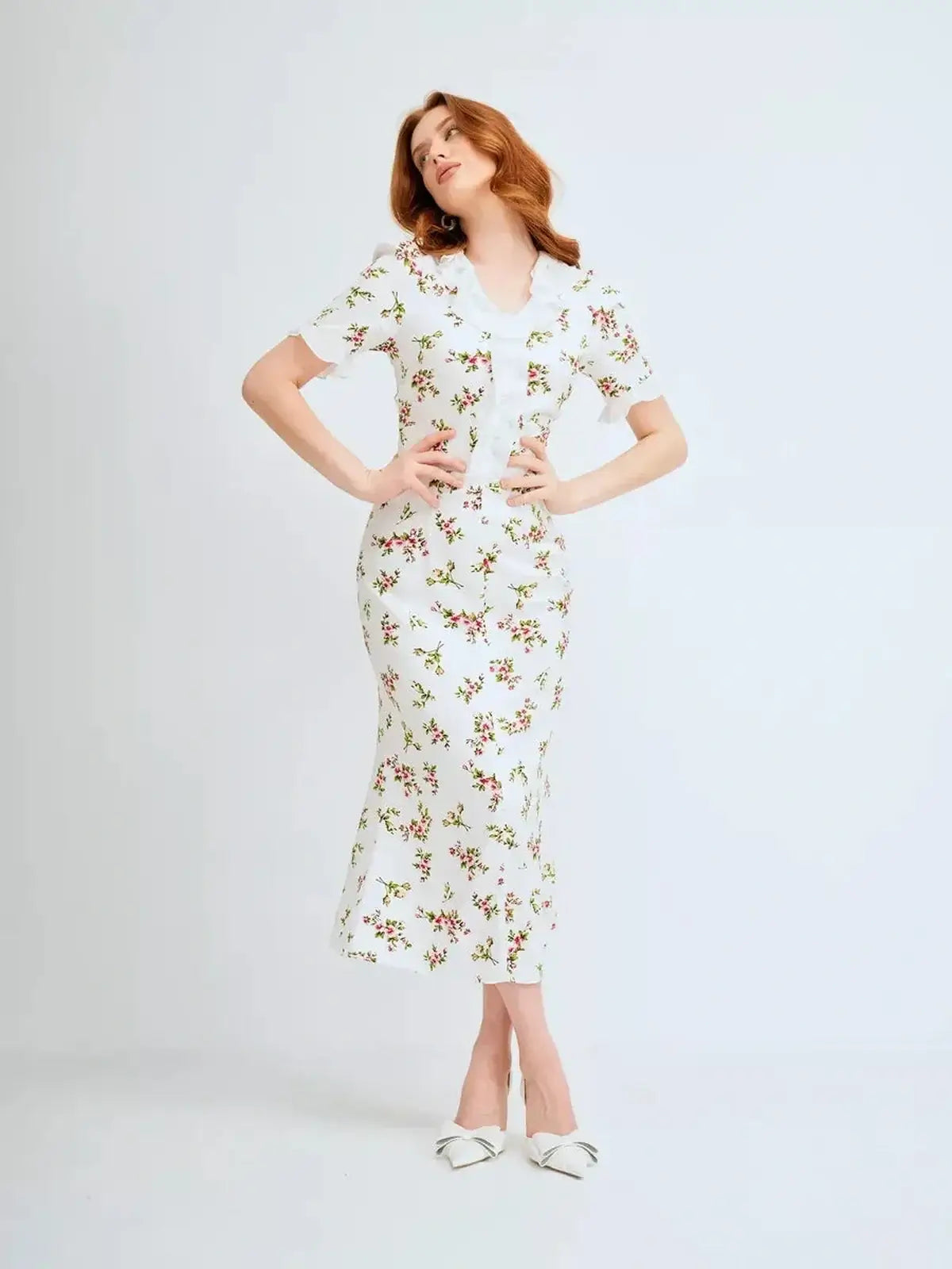 Woman in a floral white midi dress with ruffle collar, perfect for summer and special occasions.