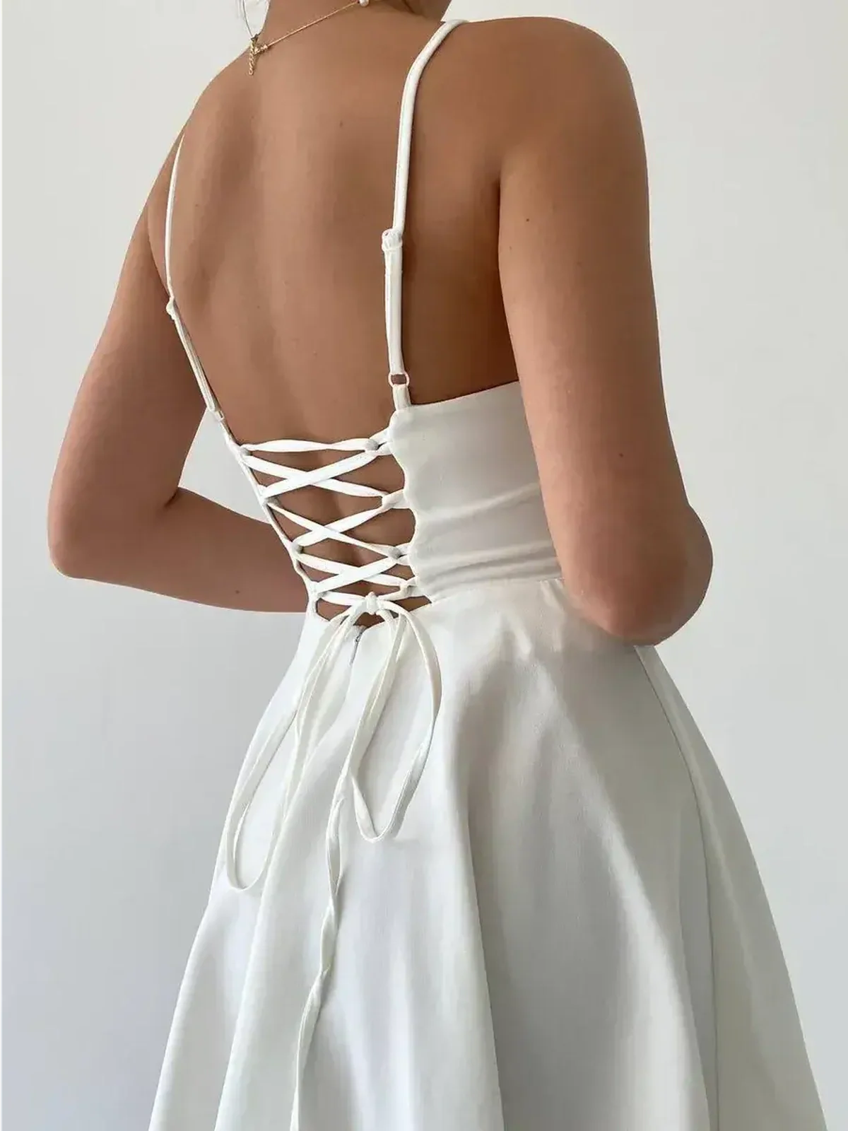 Back view of the Laceback Muse white dress showcasing an adjustable lace-up corset for a stylish summer look.