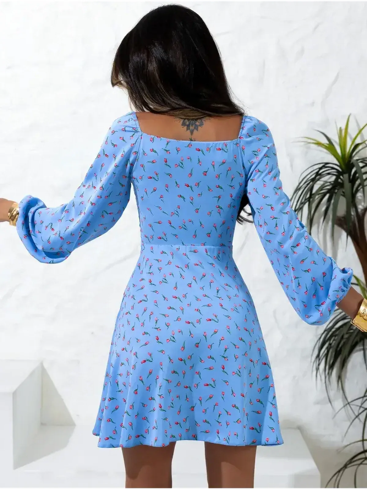 Back view of the Sky Petals mini dress, featuring soft blue fabric with floral prints, perfect for summer occasions.