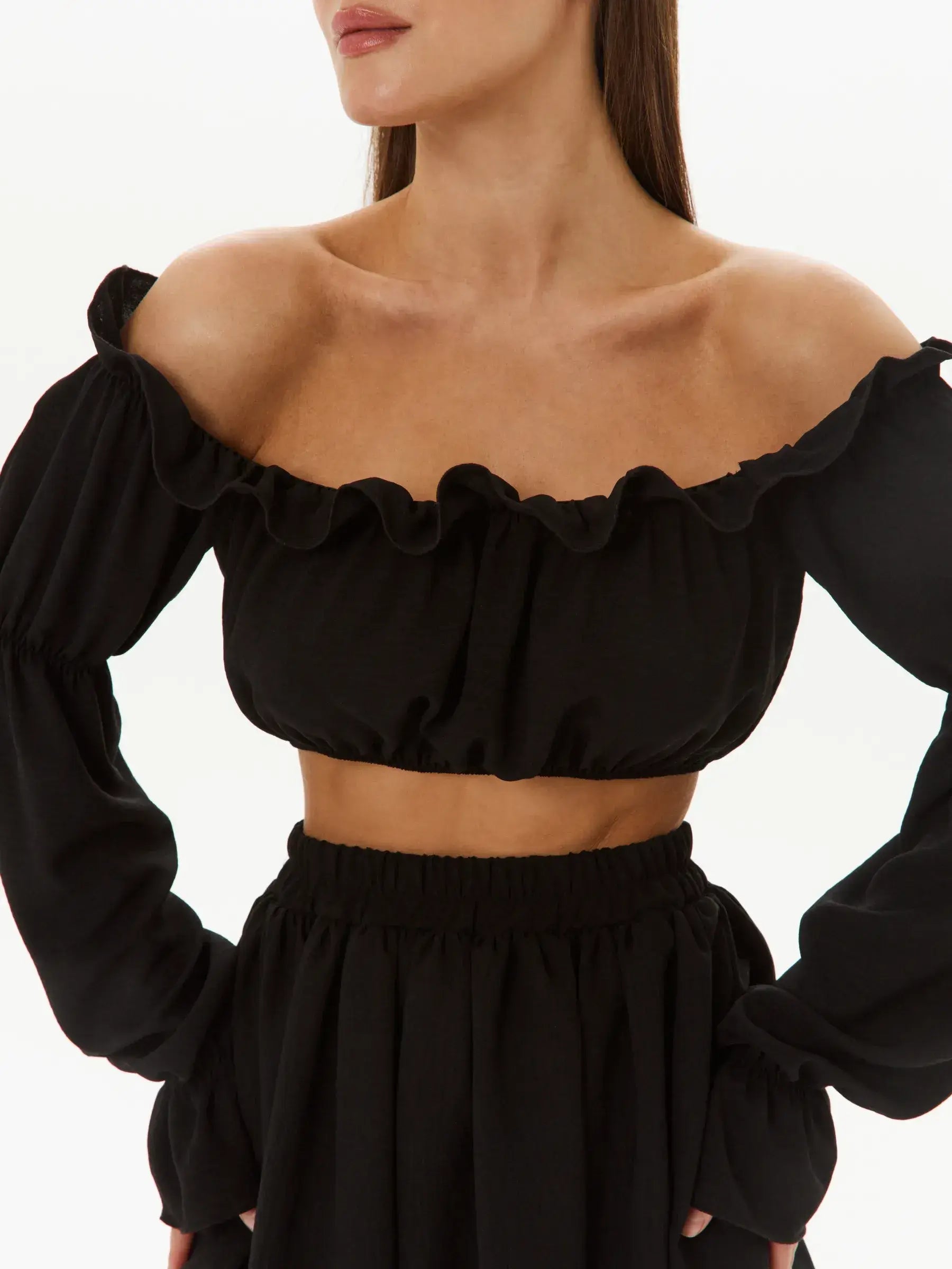 Off-shoulder ruffle crop top from the Ruffle Muse Set, paired with a tiered skirt in lightweight wrinkle-free fabric.