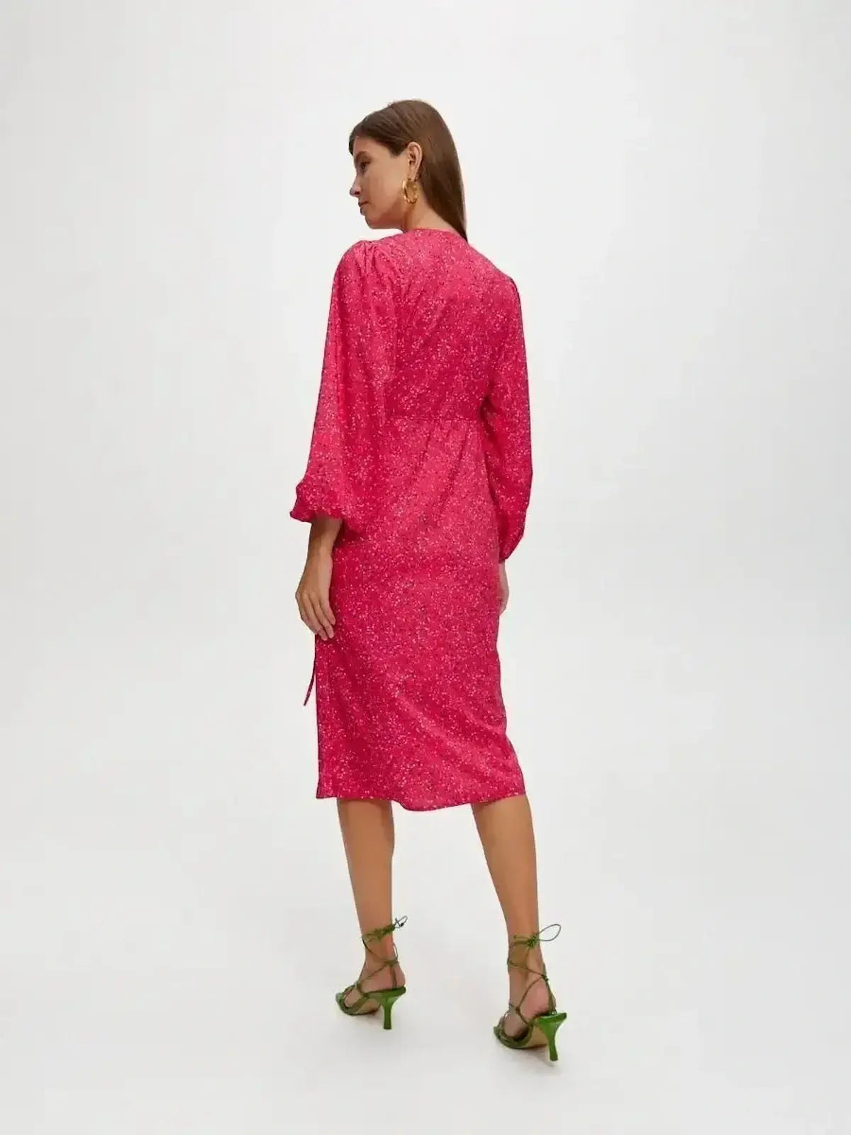 Back view of a woman in a bright pink Confetti Bloom Midi Dress, perfect for weddings and summer parties.