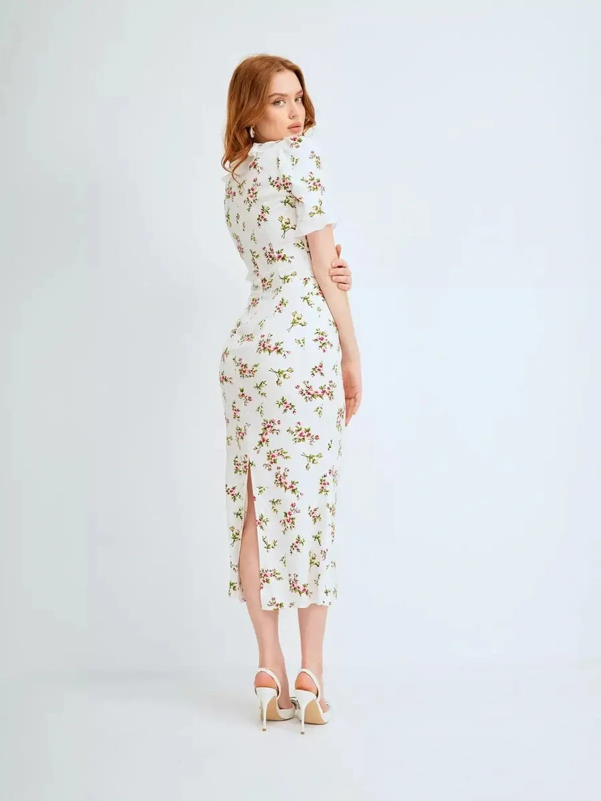 Elegant woman wearing the Roselle Midi Dress with floral print and ruffle collar, perfect for summer occasions.