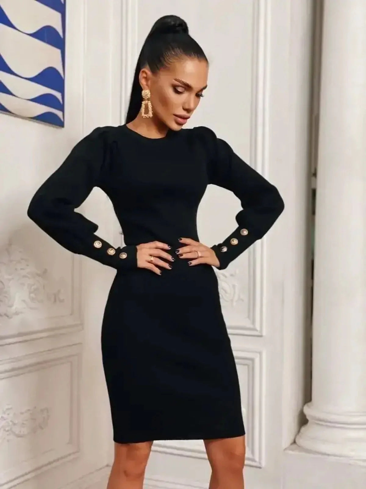 Elegant black mini dress with sculpted design, long sleeves, gathered shoulders, and gold-tone button accents.