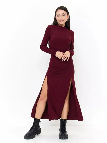 Model wearing a sleek burgundy Velvet Edge Midi Dress with thigh-high slits and a sophisticated high neckline.