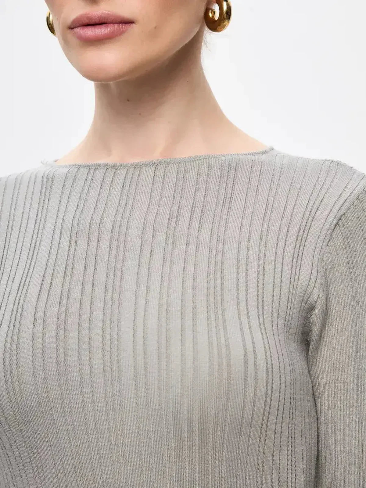 Close-up of a model wearing the Sculpted Grace Maxi Dress, showcasing its ribbed texture and elegant neckline.