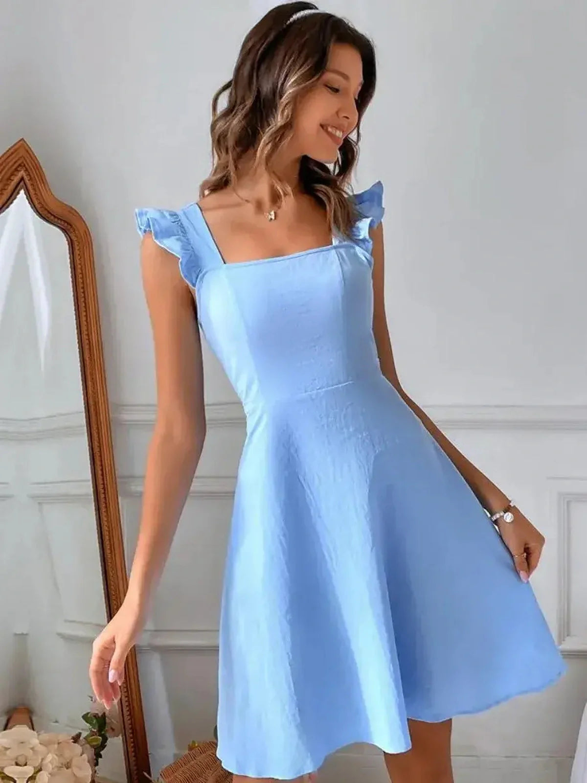 Sky Belle blue mini dress with fluttery ruffle straps, perfect for summer weddings and casual outings.