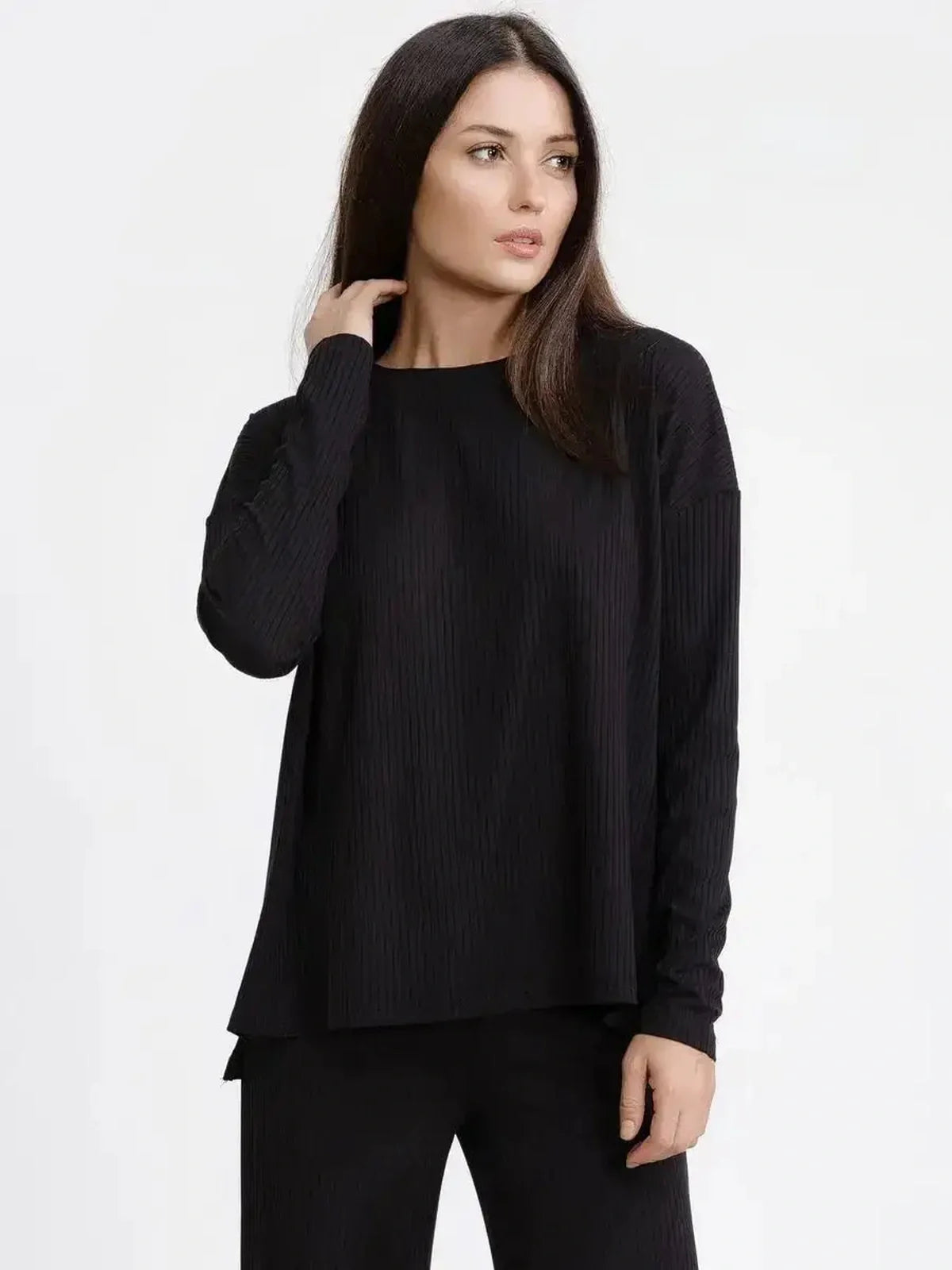 Model wearing a ribbed black long-sleeve top from the Jet Black Set, showcasing a relaxed silhouette.