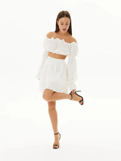 Chic white ruffle set with off-shoulder top and layered mini skirt, perfect for summer outings and special occasions.