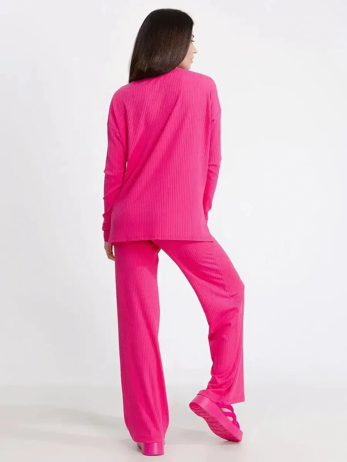 Back view of a vibrant fuchsia lounge set, oversized ribbed knit top and pants for stylish comfort.