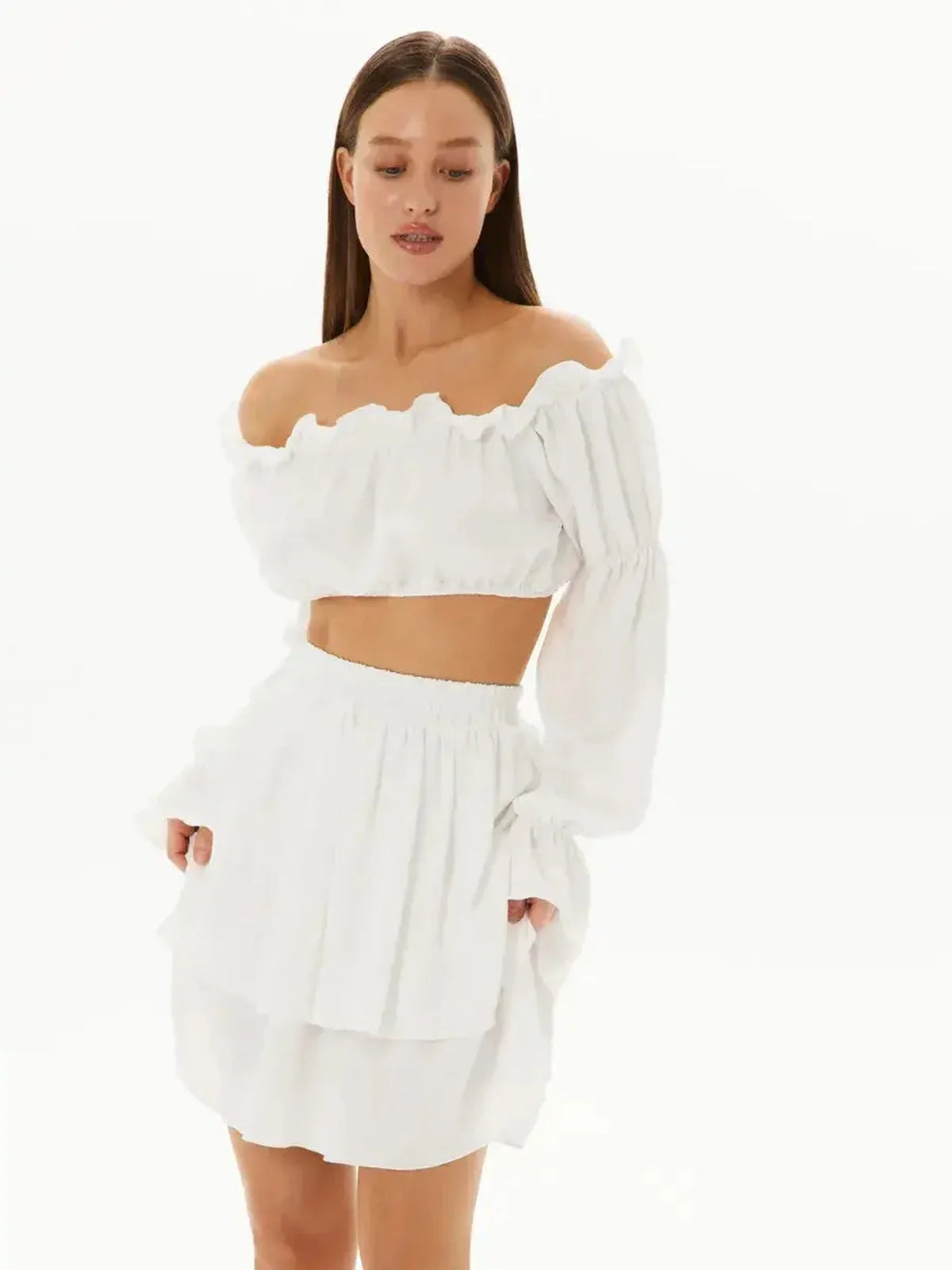 Chic white ruffle set featuring an off-shoulder top and layered mini skirt, perfect for summer events.
