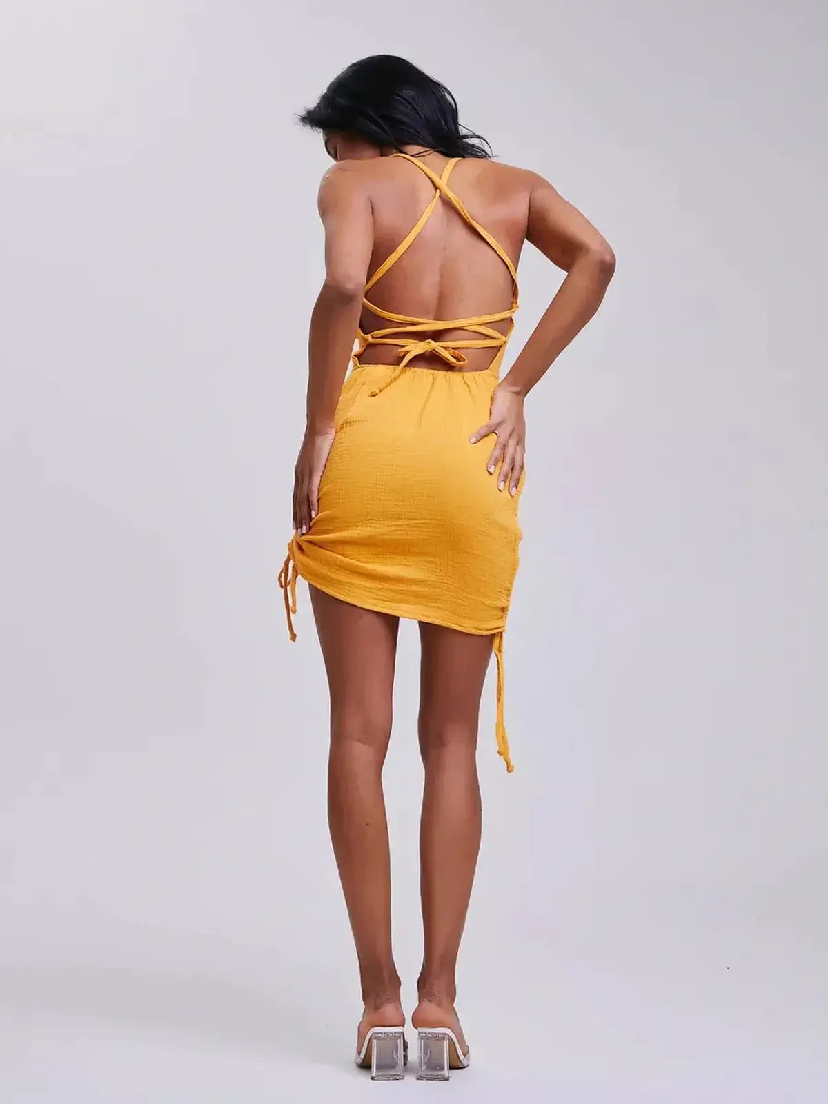 Back view of yellow mini dress with adjustable crisscross straps, perfect for summer outings and special events.