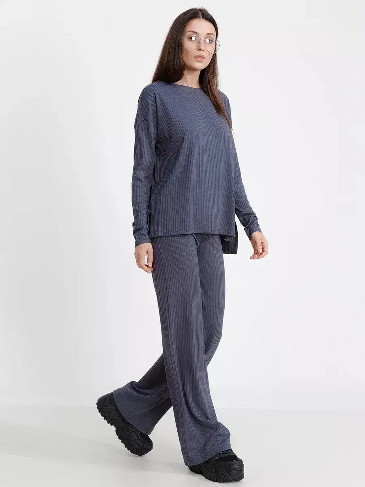 Woman modeling a Slate Lounge Set in oversized ribbed knit, featuring long sleeves and wide-leg pants for stylish comfort.