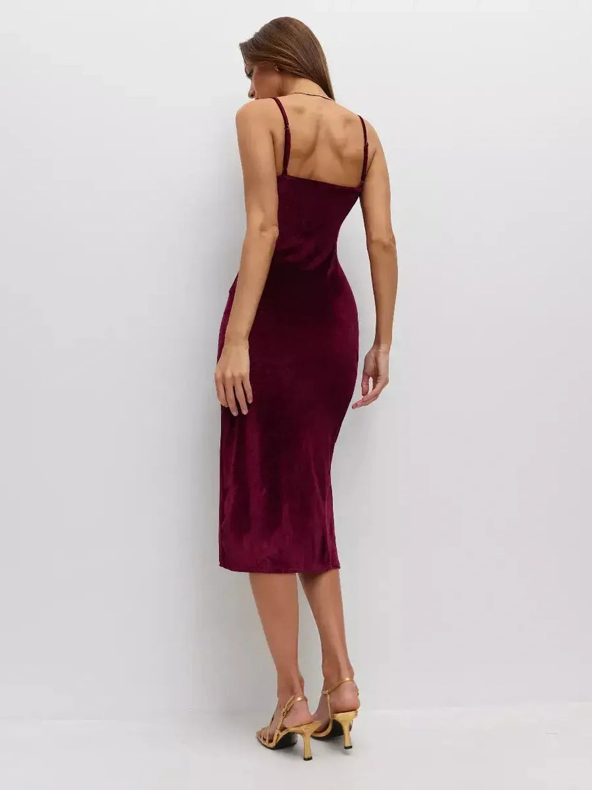 Elegant wine-toned midi dress with plush velvet fabric and deep slit, perfect for wedding guest or formal occasions.
