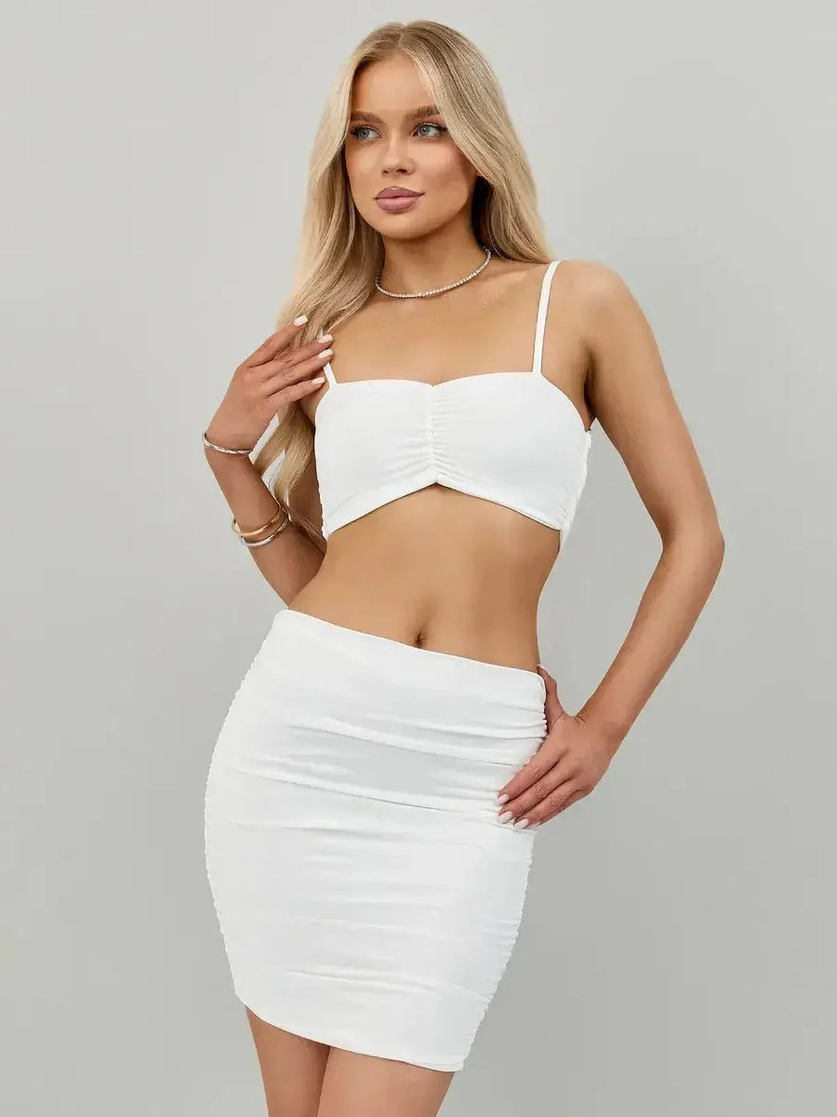 Ivory Rush Set in crisp white featuring a ruched crop top and bodycon mini skirt, perfect for summer events.