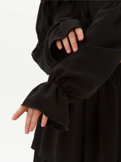 Close-up of ruffled black sleeve detail from an off-shoulder top of the Ruffle Muse Set.