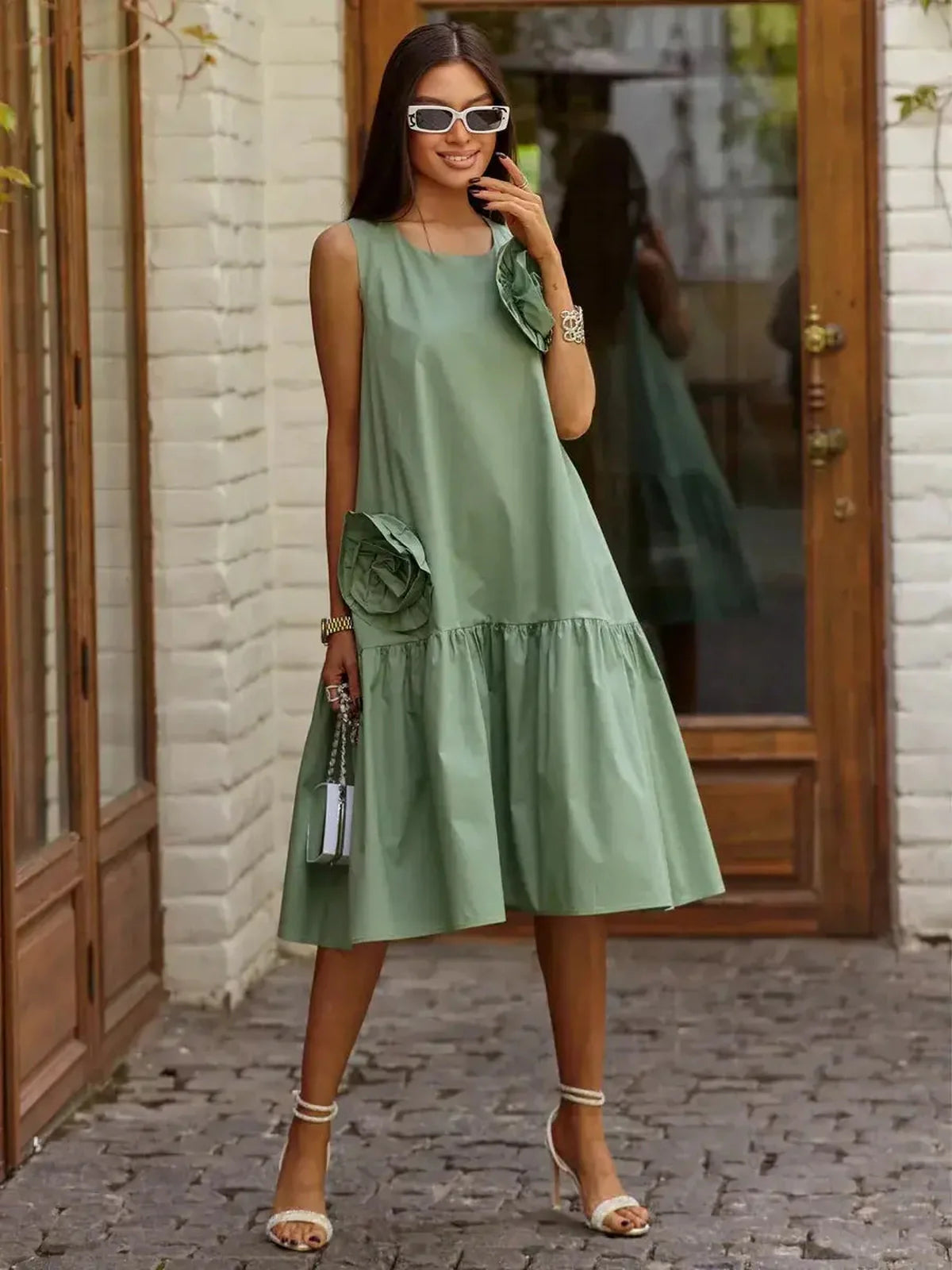 Model wearing a green Petal Bloom Midi Dress with floral accents, perfect for summer weddings and elegant occasions.