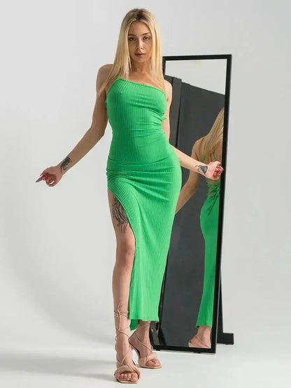Model showcasing the Maxi Dress Emerald Whisper in vibrant green with a dramatic leg slit and sleek fit.