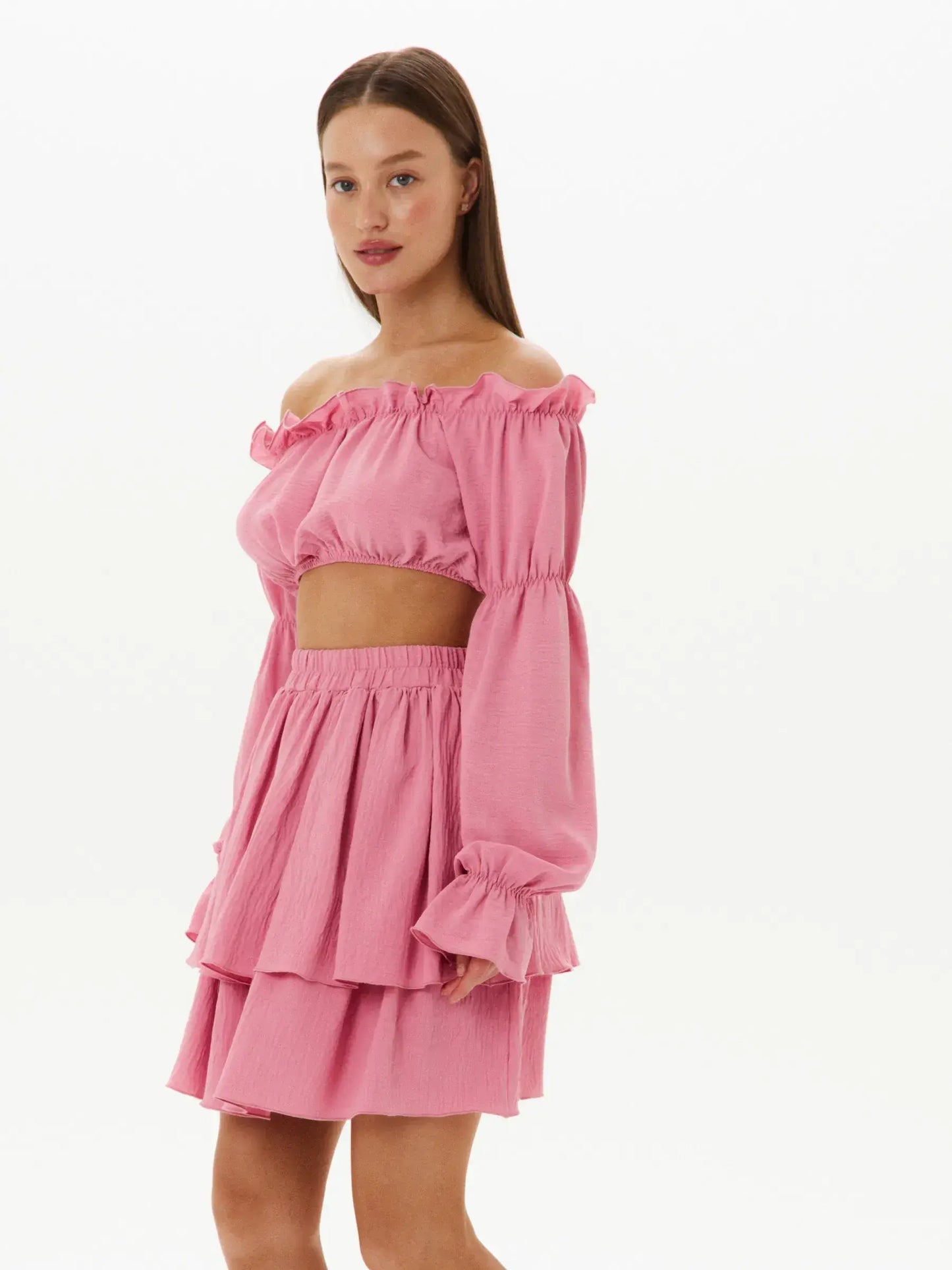 Ultra-feminine pink tiered ruffle set featuring an off-shoulder crop top and layered mini skirt for stylish summer looks.