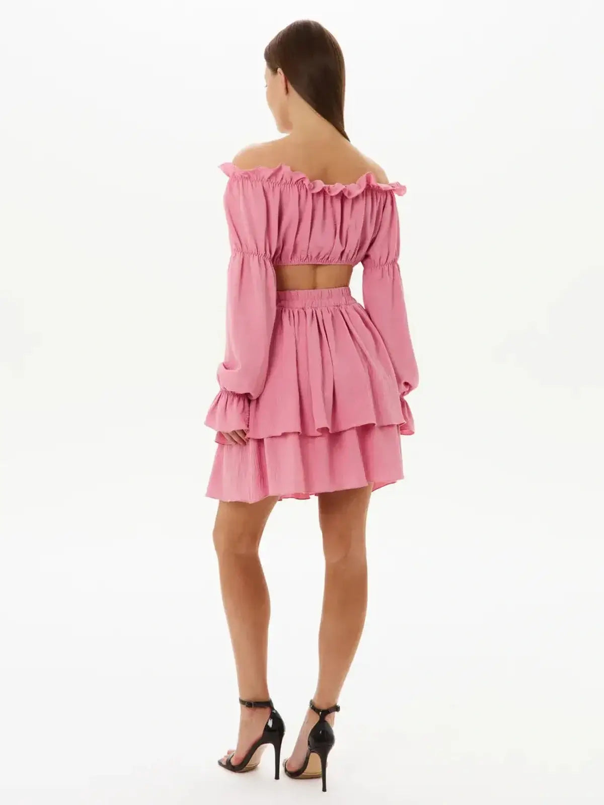 Back view of a pink tiered ruffle set featuring an off-shoulder crop top and layered mini skirt, perfect for summer events.