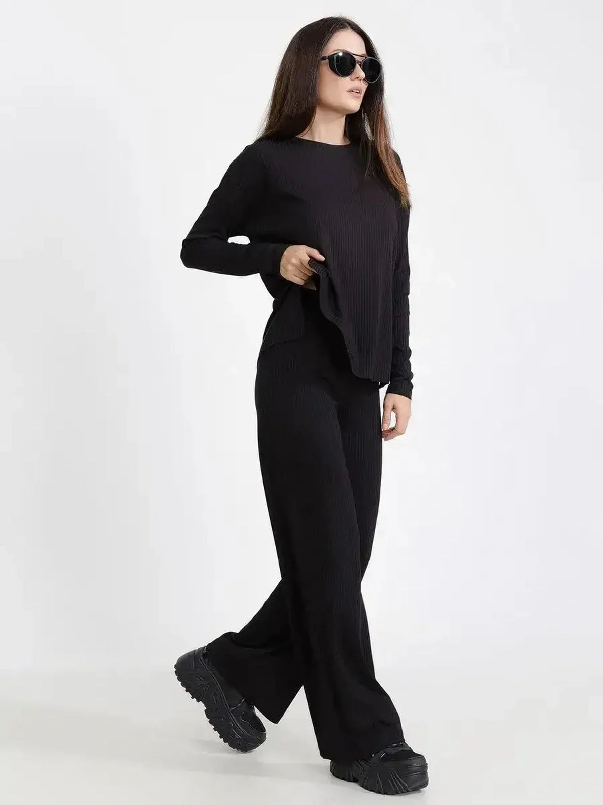 Chic model in a Jet Black ribbed two-piece set, featuring a loose-fit top and wide-leg pants, perfect for casual outings.