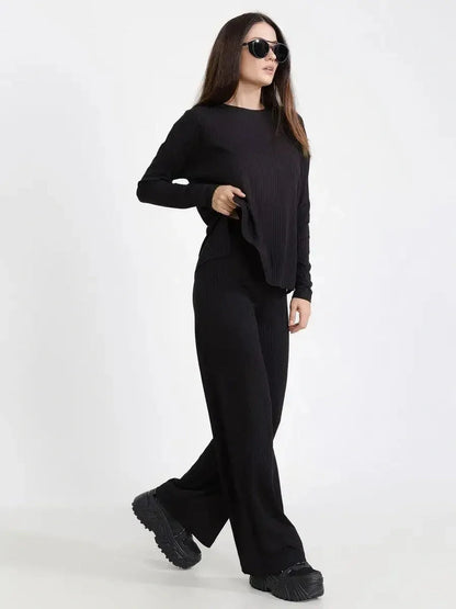 Chic model in a Jet Black ribbed two-piece set, featuring a loose-fit top and wide-leg pants, perfect for casual outings.