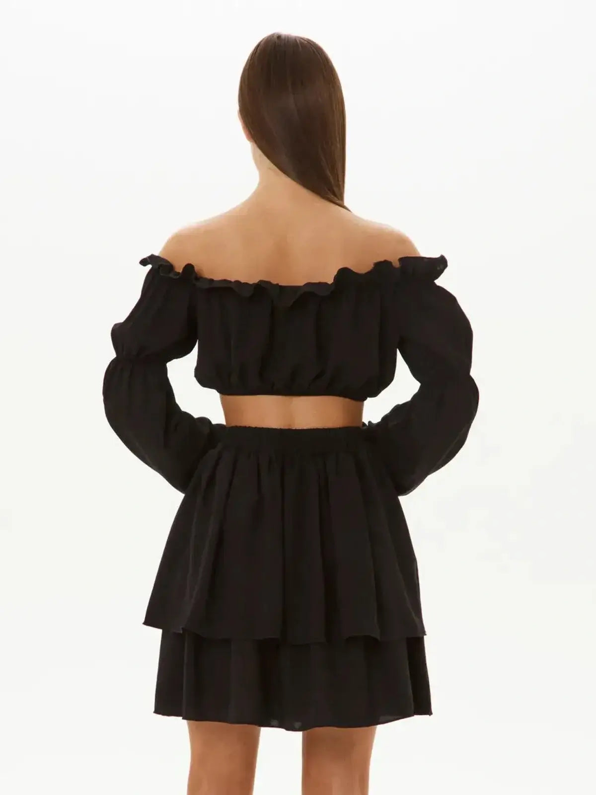 Back view of Ruffle Muse Set featuring off-shoulder crop top and tiered mini skirt in black, perfect for summer or formal occasions.