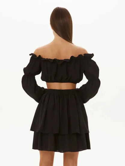 Back view of Ruffle Muse Set featuring off-shoulder crop top and tiered mini skirt in black, perfect for summer or formal occasions.