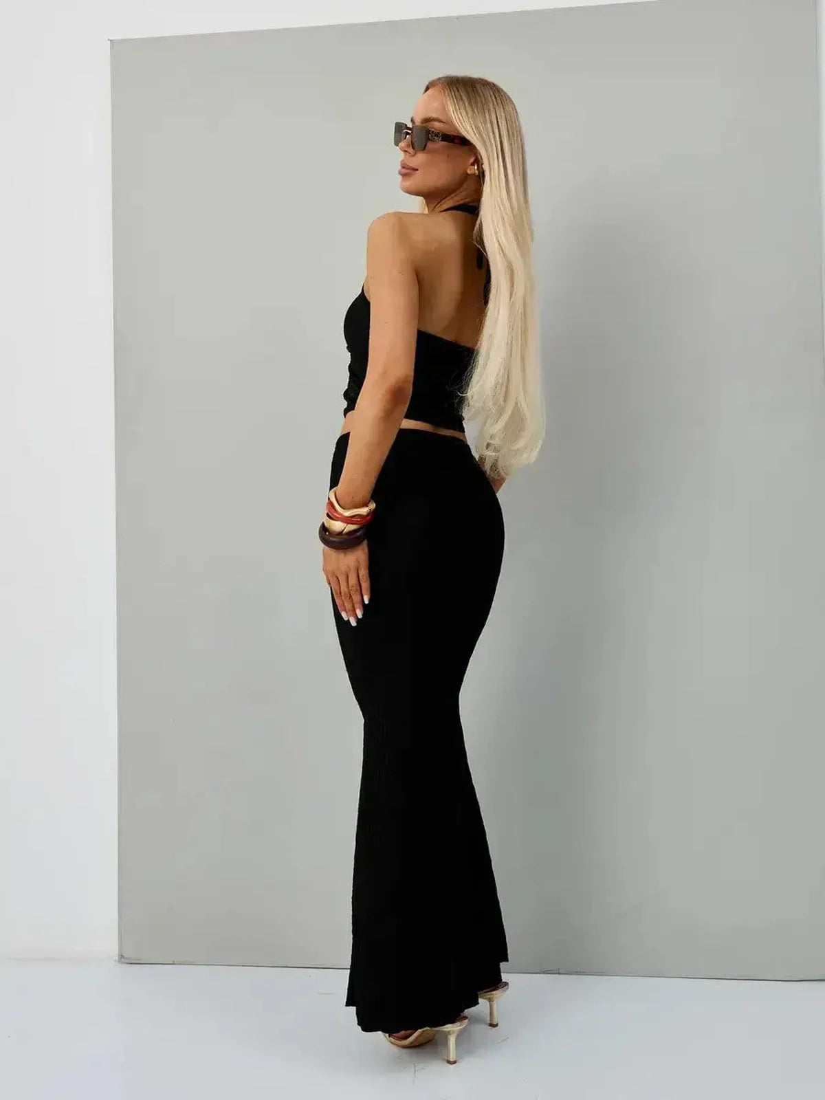Model showcasing the Noir Edge Set, a chic black halter top and maxi skirt perfect for weddings and formal events.