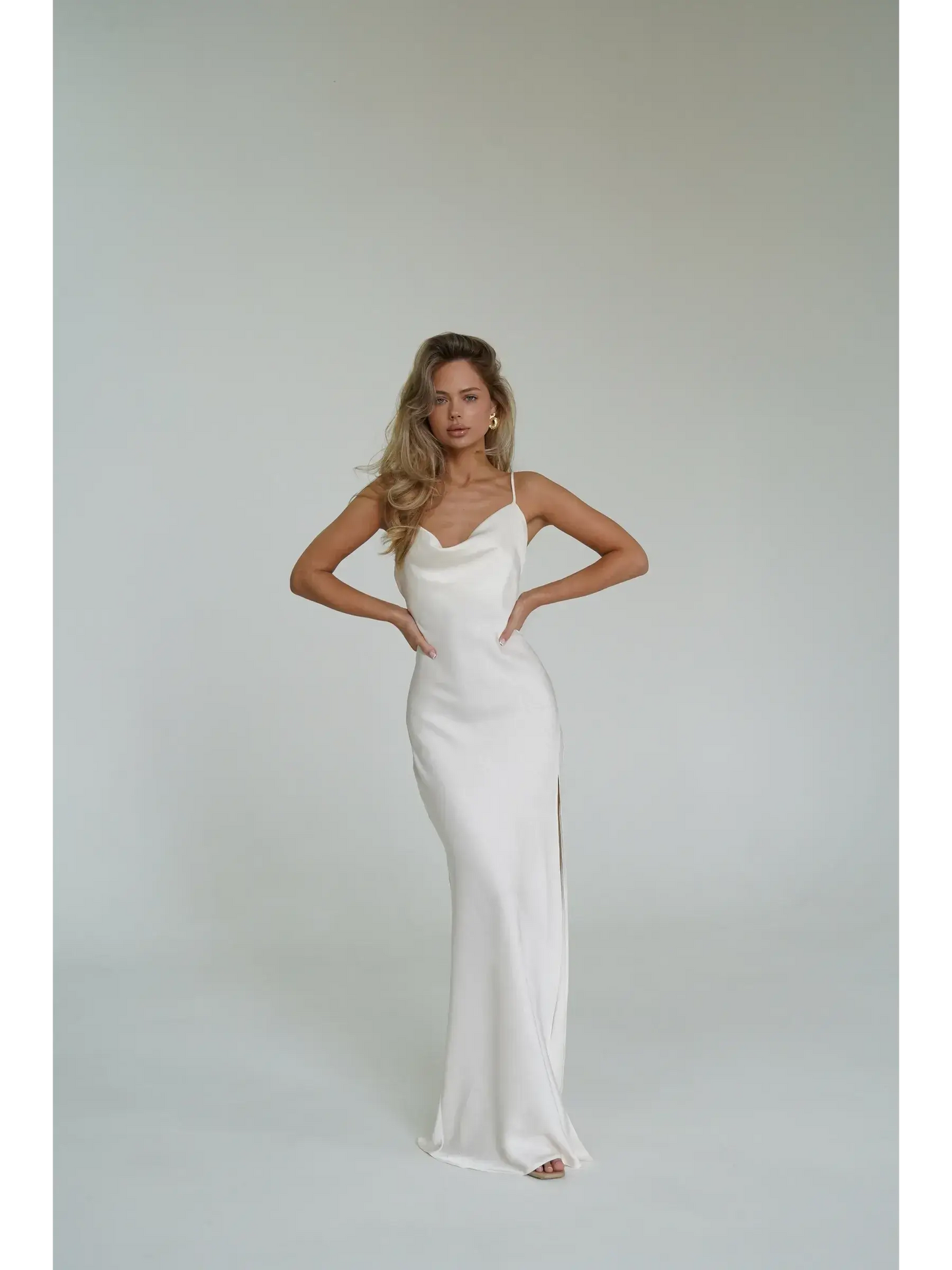 Model showcasing the Ivory Luxe Maxi Dress featuring a cowl neckline and high side slit, perfect for summer events.