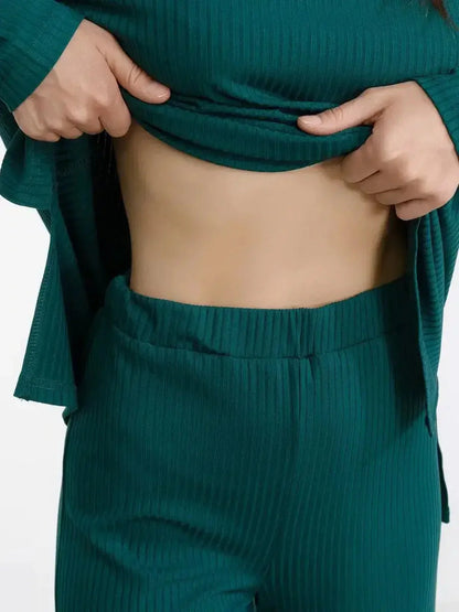 Close-up of a woman adjusting the ribbed dark green LoungeEase Set, showcasing its relaxed fit and comfort.