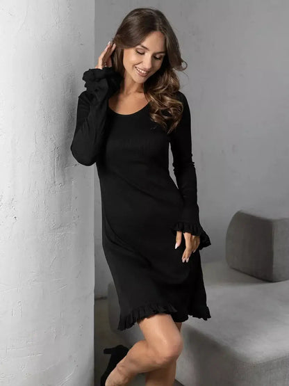 A model wearing the Noir Flare black mini dress with long sleeves and ruffled trim, showcasing a chic and flattering silhouette.